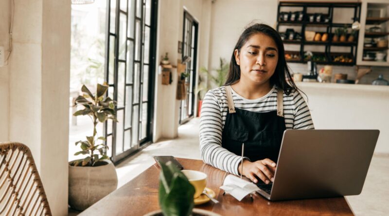 Emprendedora latina utilizando inteligencia artificial para gestionar un pequeño negocio